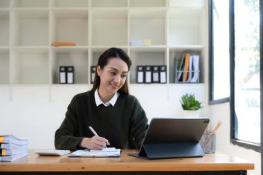 İş yerinde dizüstü bilgisayarda çalışan Asyalı genç bir iş kadınının portresi. İş adamları serbest internet üzerinden pazarlama e-pazarlama kavramını rapor ediyor.