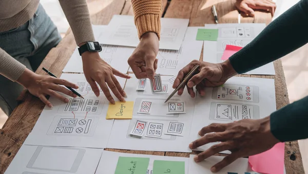 stock image Close up ux developer and ui designer brainstorming about mobile app interface wireframe design on table with customer breif and color code at modern office.Creative digital development agency..