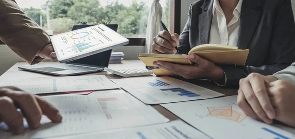 stock image Business People Meeting using laptop computer,calculator,notebook,stock market chart paper for analysis Plans to improve quality next month. Conference Discussion Corporate Concept.