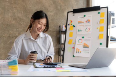 Ofiste dizüstü bilgisayarda çalışan genç bir kadın. Ofisteki iş yerinde oturan Asyalı iş kadını. Güzel Freelancer Kadını evinde çalışıyor.