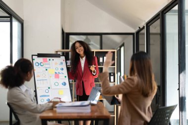 Asyalı kadın liderle birlikte Asyalı iş grubu tasarımcıları ekibi evrak işlerini tartıştılar. İstatistiksel veriler, ortak proje üzerine tahminler. Beyin fırtınası, bilgilendirme etkinliği konsepti..