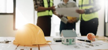 İnşaat mühendisi takımları modern kentteki inşaat sahasında birlikte çalışan işçi kaskı takıyorlar. Foreman Endüstri Mühendislik Mühendisliği ekip çalışması. Asya endüstrisi profesyonel takımı...