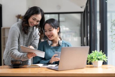 İki genç Asyalı iş kadını mali yönetim planlarını tartışıyor. Finansal planlama ve istatistik ve yatırım pazarı hakkında yeni başlangıç projesi fikirleri analizi