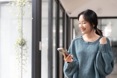 Genç Asyalı güzel kadın akıllı telefonu iş için kullanıyor, online alışveriş, para transferi, finans, internet bankacılığı