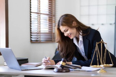 Asyalı güzel bir kadın avukat çalışıyor ve tokmak, tablet, dizüstü bilgisayar, danışmanlık ve hukuk konsepti