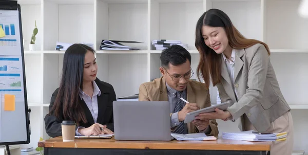 Group of young asian business people in smart casual wear working together in creative office using laptop...