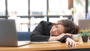 Üzgün genç kadın çalışanın borçları ve mali durumuyla ilgili sorunları var. Hüsrana uğramış Asyalı güzel iş kadını ofiste çalışırken depresyonda, yorgun, tembel....