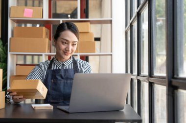 Küçük işletmeler kuran KOBİ 'li kadın girişimciler rakamlar sipariş ediyor, kutuları paketlemek, müşterilere satmak, çevrimiçi iş fikirleri hazırlamak için çevrimiçi siparişler alıyor ve gözden geçiriyorlar...