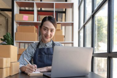 Küçük işletmeler kuran KOBİ sahipleri kadın girişimciler, çevrimiçi siparişleri kontrol ederek kutuları paketlemeye, müşterilere satmaya ve iş fikirlerini internette satmaya hazırlanıyorlar....