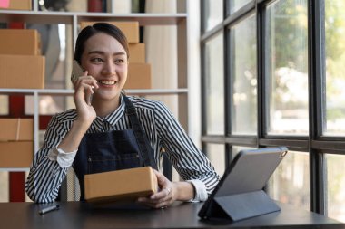 Küçük işletme sahipleri iş yerinde bilgisayar ve telefon kullanıyorlar, satıcılar üretim siparişlerini kontrol ediyorlar. Ürünleri müşterilere yollamak, nakliye fikirleri satmak için paketleyin...