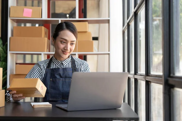 Küçük işletmeler kuran KOBİ 'li kadın girişimciler rakamlar sipariş ediyor, kutuları paketlemek, müşterilere satmak, çevrimiçi iş fikirleri hazırlamak için çevrimiçi siparişler alıyor ve gözden geçiriyorlar...