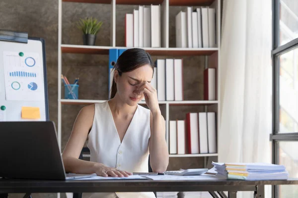 Young Business Asian women are stressed while working on laptop, Tired asian businesswoman with headache at office, feeling sick at work copy space in workplace an home office...