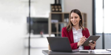 Business woman using calculator for do math finance on wooden desk in office and business working background, tax, accounting, statistics