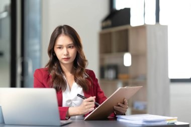 Ofiste dizüstü bilgisayarda çalışan genç bir kadın. Ofisteki iş yerinde oturan Asyalı iş kadını. Güzel Freelancer Kadını evinde çalışıyor.