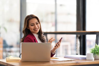 Gülümseyen Asyalı iş kadını. Çizelgeyi ve grafiği analiz ediyor. Piyasadaki değişiklikleri gösteriyor....
