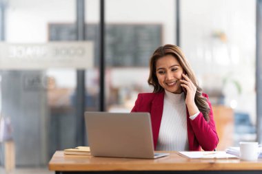 Gülümseyen Asyalı iş kadını. Çizelgeyi ve grafiği analiz ediyor. Piyasadaki değişiklikleri gösteriyor....