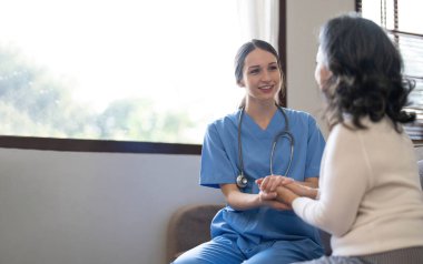 Mutlu hasta, birlikte zaman geçirirken bakıcıya yardım ediyor. Huzurevindeki yaşlı kadın ve hemşire. Yaşlanmış zarif bir kadın ve huzurevinde çay saati..