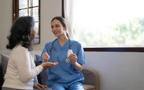 Asian nurse showing health checkup report to grandmather and giving advice. medical assisted living visit senior patient at home. Home nursing and healthcare caregiver concept..