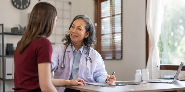 stock image Serious doctor visiting female patient, giving consultation, recommendations, listening to complaints. woman complaining on healthcare problems to physician in white coat..