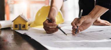 İnşaat mühendisi takımları modern kentteki inşaat sahasında birlikte çalışan işçi kaskı takıyorlar. Foreman Endüstri Mühendislik Mühendisliği ekip çalışması. Asya endüstrisi profesyonel takımı