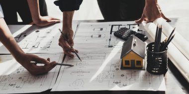 İnşaat mühendisi takımları modern kentteki inşaat sahasında birlikte çalışan işçi kaskı takıyorlar. Foreman Endüstri Mühendislik Mühendisliği ekip çalışması. Asya endüstrisi profesyonel takımı