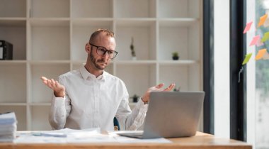 Genç mutsuz ofis çalışanı işte sıkılmış hissediyor. Ofiste çalışırken yüzü dağılmış dizüstü bilgisayara bakıyor. Dikkati dağılmış bir erkek işçi monoton bir işten bıkıp usanmış hissediyor...