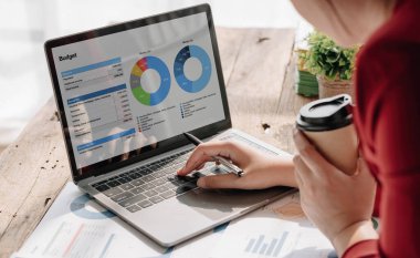 Business woman using laptop for do math finance on wooden desk in office and business working background, tax, accounting, statistics and analytic research concept....