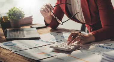 İş kadını, ofis ve iş geçmişinde, vergi, muhasebe, istatistik ve analitik araştırma kavramında matematik finansmanı için hesap makinesi kullanıyor....