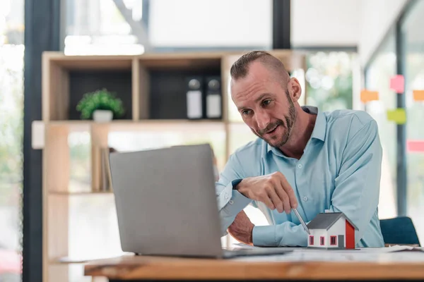 stock image Professional and smart Caucasian male engineer having an online meeting with his team, explaining the building plan and design, working in the office...