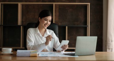 İş kadını matematik finansmanı için hesap makinesi kullanıyor. Ev ve iş hayatında ahşap masa, vergi, muhasebe, istatistik ve analitik araştırma konsepti.....