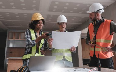 İnşaat mühendisi takımları modern kentteki inşaat sahasında birlikte çalışan işçi kaskı takıyorlar. Foreman Endüstri Mühendislik Mühendisliği ekip çalışması. Asya endüstrisi profesyonel takımı...