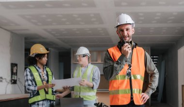 Erkek Mühendislerin Liderlik kavramı: Bir grup erkek inşaat işçisinin önünde mutlu bir erkek mühendisin portresi: Etkili takım çalışması..