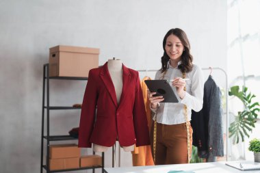Ticaret, küçük işletme ve telefon görüşmesi, tabletli bir kadın satış siparişleri alıyor ve envanteri kontrol ediyor. Akıllı telefondan müşteri hizmetleri, online alışveriş başarısı ve kız patron, teslimat için bizimle irtibata geçin.