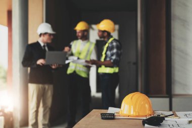 İnşaat mühendisi takımları modern kentteki inşaat sahasında birlikte çalışan işçi kaskı takıyorlar. Foreman Endüstri Mühendislik Mühendisliği ekip çalışması. Asya endüstrisi profesyonel takımı...
