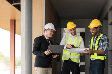 İnşaat mühendisi takımları modern kentteki inşaat sahasında birlikte çalışan işçi kaskı takıyorlar. Foreman Endüstri Mühendislik Mühendisliği ekip çalışması. Asya endüstrisi profesyonel takımı...