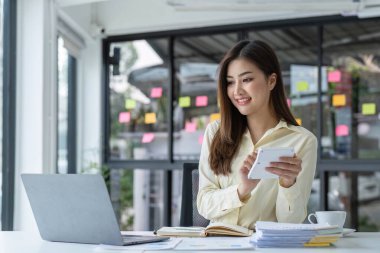 İş kadını, ofis ve iş geçmişinde, vergi, muhasebe, istatistik ve analitik araştırma kavramında matematik finansmanı için hesap makinesi kullanıyor....