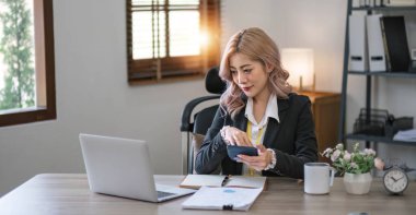 İş kadını, ofis ve iş geçmişinde, vergi, muhasebe, istatistik ve analitik araştırma kavramında matematik finansmanı için hesap makinesi kullanıyor....