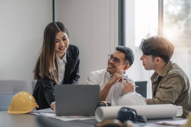 İnşaat mühendisi takımları modern kentteki inşaat sahasında birlikte çalışan işçi kaskı takıyorlar. Foreman Endüstri Mühendislik Mühendisliği ekip çalışması. Asya endüstrisi profesyonel takımı...