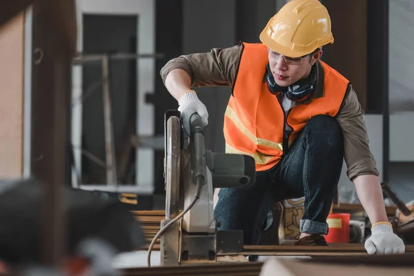 stock image Carpenter working on wood craft at workshop to produce construction material or wooden furniture. The young Asian carpenter use professional tools for crafting. DIY maker and carpentry work concept. 