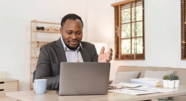 İş yerindeki video görüşmelerine katılmak için dizüstü bilgisayar kullanan bir finans analisti. İnternet telekomünikasyon ve tele-çalışma konferansı için uzaktan video konferansında konuşan bir ofis çalışanı....