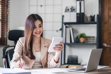 İş kadını, ofis ve iş geçmişinde, vergi, muhasebe, istatistik ve analitik araştırma kavramında matematik finansmanı için hesap makinesi kullanıyor....