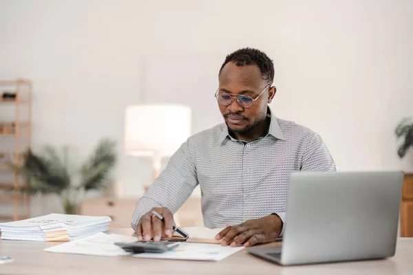 stock image Portrait of handsome African black young business man working on laptop at office desk...