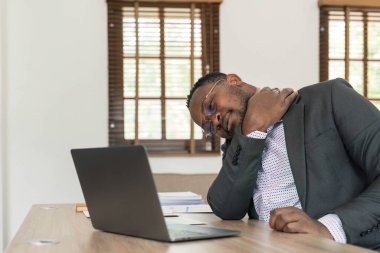 Young african man working at the office using computer laptop suffering pain on hands and fingers, arthritis inflammation...