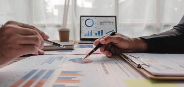 İki iş adamı toplantı odasında proje stratejisi hakkında konuşuyor. İş adamı sohbet ederken modern işyerindeki meslektaşıyla proje planlamasını tartıştı