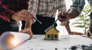 İnşaat mühendisi takımları modern kentteki inşaat sahasında birlikte çalışan işçi kaskı takıyorlar. Foreman Endüstri Mühendislik Mühendisliği ekip çalışması. Asya endüstrisi profesyonel takımı