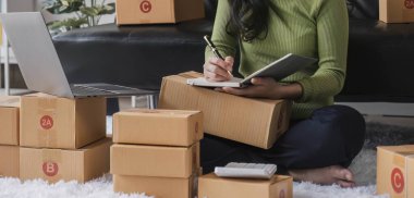Küçük işletme girişimcisi KME, kutuda kumaş paketleyen Asyalı kadın. Portre genç Asyalı küçük işletme sahibi ev sahibi, çevrimiçi satış pazarlama teslimatı, KME e-ticaret tele pazarlama kavramı