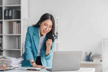 Güzel Asyalı kız dizüstü bilgisayar, başarı mutlu poz ile kutlamak. E-ticaret, üniversite eğitimi, internet teknolojisi veya başlangıç küçük işletme kavramı. Modern ofis veya fotokopi alanı ile oturma odası..