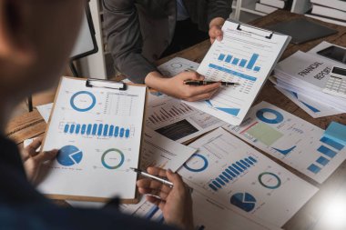 Business People Meeting using laptop computer,calculator,notebook,stock market chart paper for analysis Plans to improve quality next month. Conference Discussion Corporate Concept