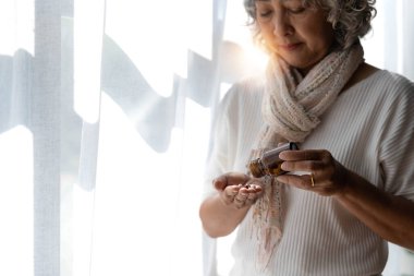 Asyalı yaşlı bir kadın eczaneden bitkisel kendini tedavi hapı alıyor. Son sınıf öğrencisi endişeli bir kadın, okuduğu ilaçlarla nasıl hap alınacağını görüyor. Evde tecrit, tıbbi servis konsepti...