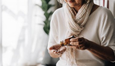 Asyalı yaşlı bir kadın eczaneden bitkisel kendini tedavi hapı alıyor. Son sınıf öğrencisi endişeli bir kadın, okuduğu ilaçlarla nasıl hap alınacağını görüyor. Evde tecrit, tıbbi servis konsepti...